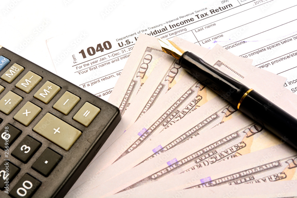 Calculating US tax with 1040 tax form on white background Calculating US tax with 1040 tax form on white background