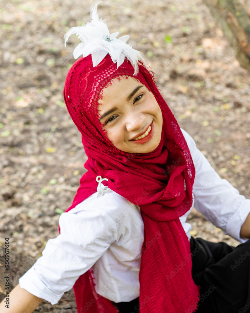 Women muslim, women islamic,wearing a red fabric head covering adorn with white fabric flowers wear shirt white photography portrait close up the face before to ramadan month. Women muslim, women islamic,wearing a red fabric head covering adorn with white fabric flowers wear shirt white photography portrait close up the face before to ramadan month.
