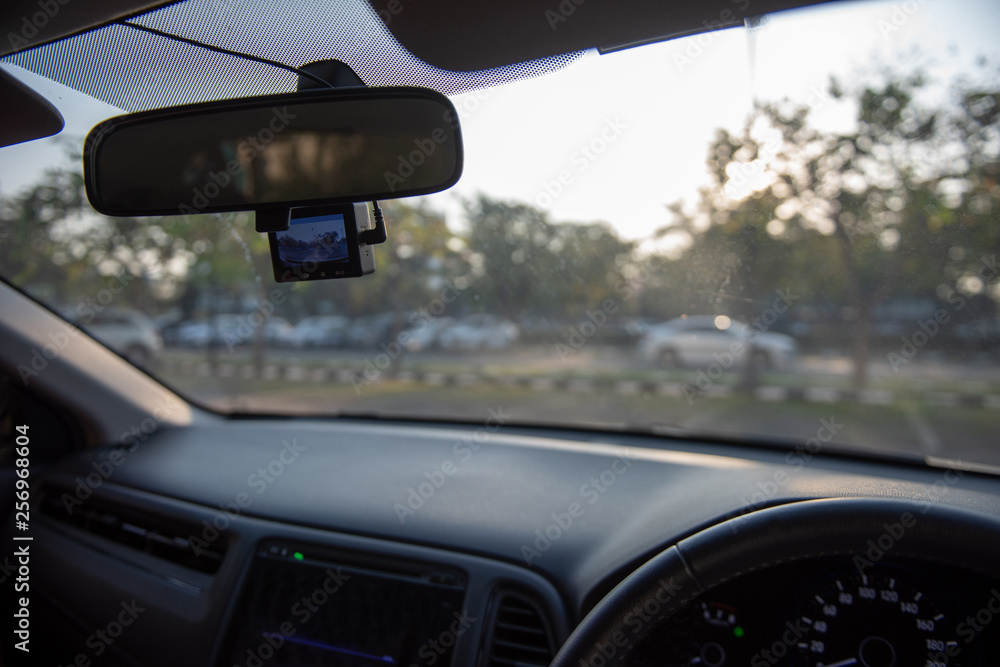 Car camera set ready for recording in front of car while a driver is ready to drive a car off the parking lot in the morning. Car camera set ready for recording in front of car while a driver is ready to drive a car off the parking lot in the morning.