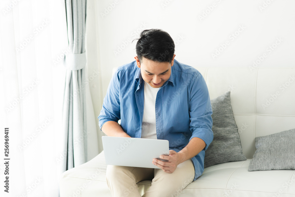 Asian man using laptop at home, lifestyle concept with copy space. Asian man using laptop at home, lifestyle concept with copy space.