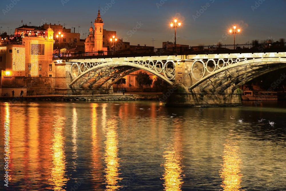 Isabel II bridge or Triana bridge over Guadalquivir river at twilight, Seville, Andalusia, Spain
