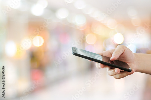 Hand using smart phone over blur bokeh light background, mock up, business and technology, internet of things concept