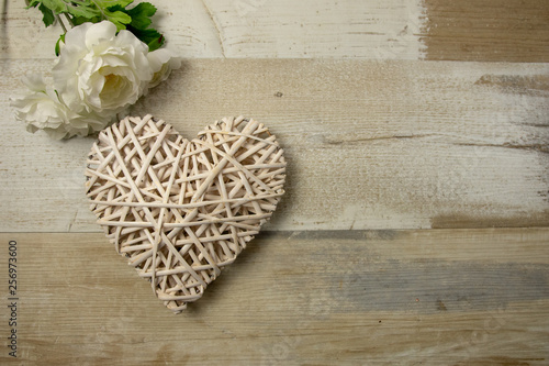 White wood wicker heart on the timber wooden background