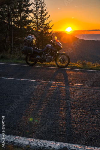 Adventure motorcycle  silhouette touristic motorbike. the mountain peaks in the sunset. Copy space. Concept of Tourism  adventures  active lifestyle  Transfagarasan  Romania  vertical photo