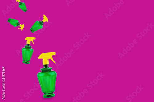 Falling plastic sprayers on pink background with copy space for your text