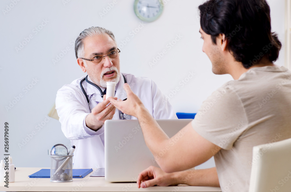 Obraz premium Young man visiting old male doctor