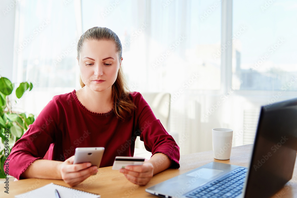 Confident businesswoman paying with credit card on smart phone at home office, copy space. Technology, banking, business, online payment, shopping concept Confident businesswoman paying with credit card on smart phone at home office, copy space. Technology, banking, business, online payment, shopping concept