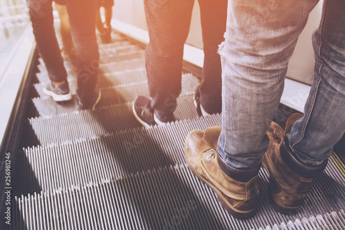close up legs shoes people crowd using escalator electronic system moving. vintage filter. Staircase Escalator Inside the Underground Metro Subway Station.