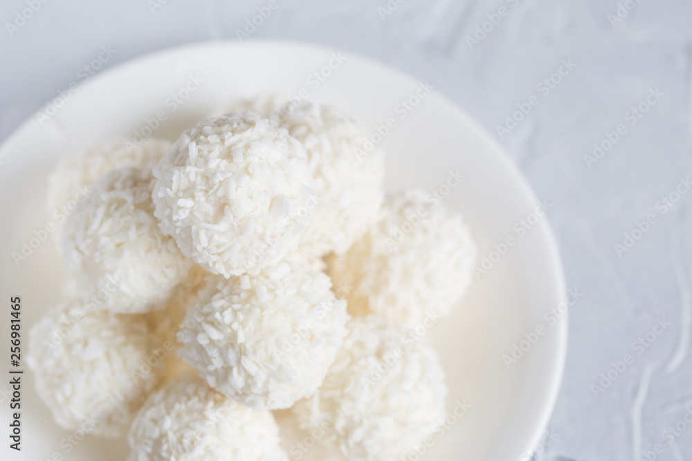 Round, white candies in coconut flakes Round, white candies in coconut flakes