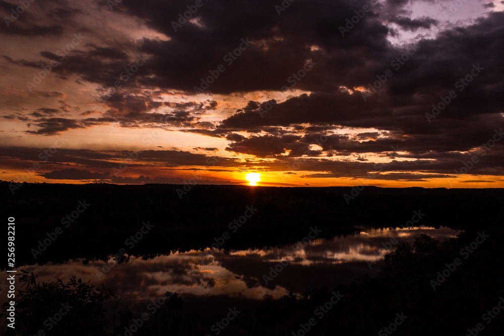 Obraz premium shot through tress of a beautiful sunset in the australian outback with 1 lakes, Nitmiluk National Park, Australia