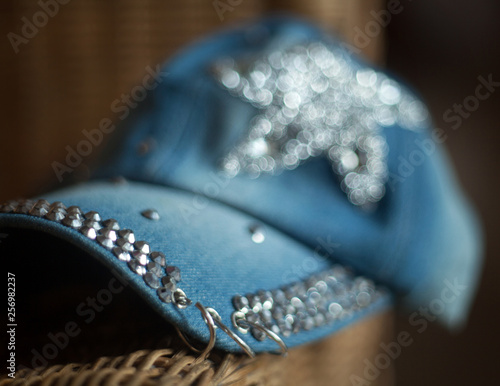 Denim cap with rhinestones and metal rings with a blurred background and bokeh
