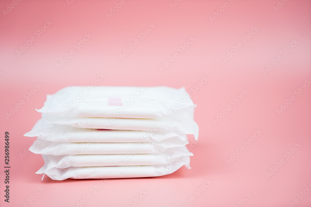 Stacked sanitary napkin pad on pink background. - obrazy, fototapety, plakaty 