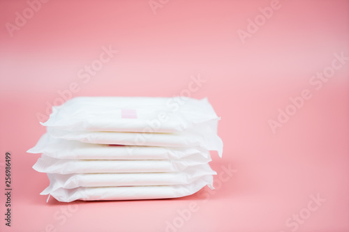 Stacked sanitary napkin pad on pink background.