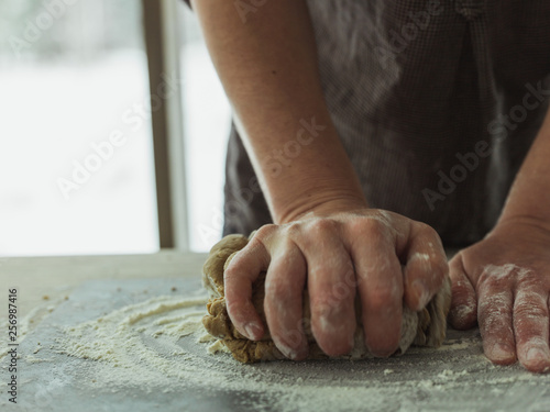 hands of baker kneading dough