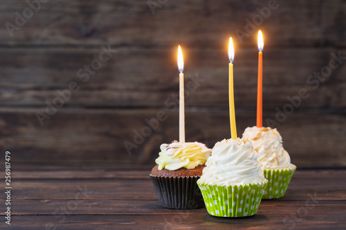 birthday cupcakes with candles on old dark  wooden background