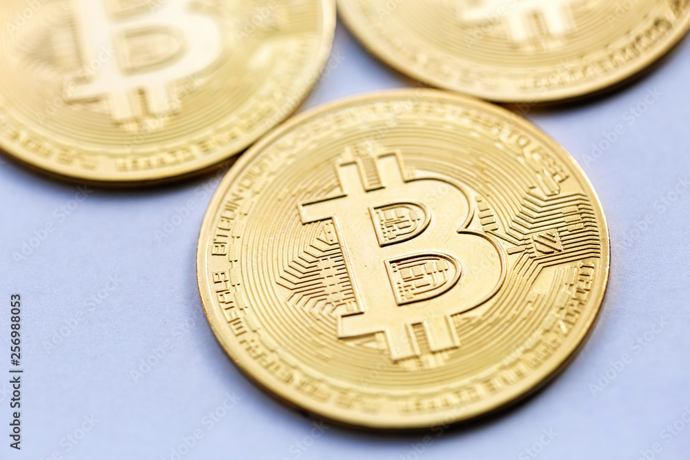 Golden Bitcoin close up, next to other coins out of focus Golden Bitcoin close up, next to other coins out of focus
