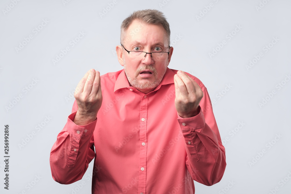 Senior man looking angry showing italian gesture. Senior man looking angry showing italian gesture.