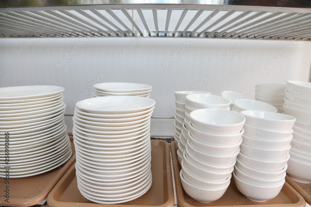 Obraz premium White set of ceramic including plate, dish, cup stacking up the rack for kitchen and restaurant organizing design 