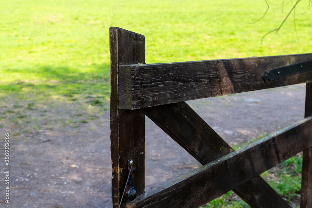 wooden gate way to ranch old big wicket gate windblown wood on the background of an earthen path pasture
