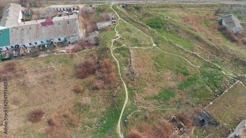 Aerial flight on drone above ruins of ancient fortress in Kerch, Crimea. Old building on sea coast with castle tower and broken walls. Archeology historical heritage. photo