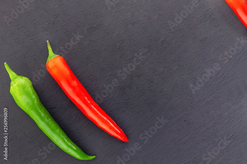 pair red bright pod hot chili peppers green oblique vegetable corner on a black background