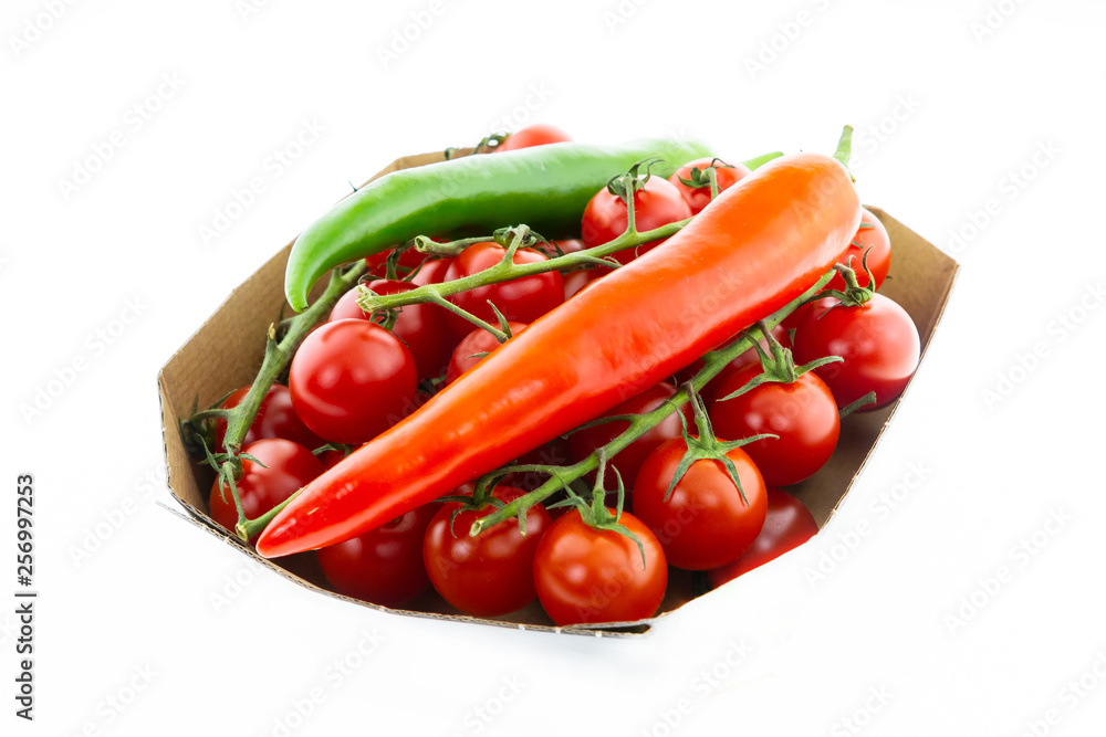 bright red pod of hot peppers long juicy vegetable on a tomato mini background on a green branch on a white background bright red pod of hot peppers long juicy vegetable on a tomato mini background on a green branch on a white background