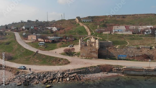 Aerial flight on drone above ruins of ancient fortress in Kerch, Crimea. Old building on sea coast with castle tower and broken walls. Archeology historical heritage. photo