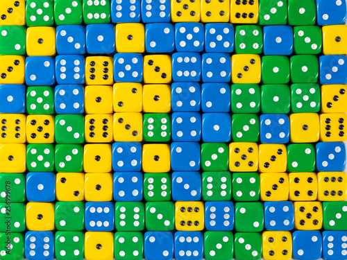 Background pattern of random ordered yellow, green and blue dices