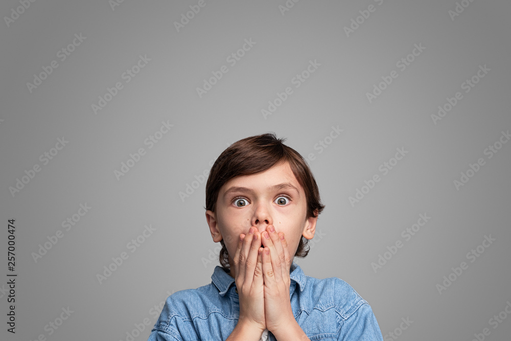 Shocked boy covering mouth Shocked boy covering mouth