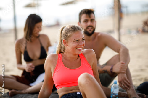 Portrait of beautiful young blond with a smile on his face on the beach with friends behind