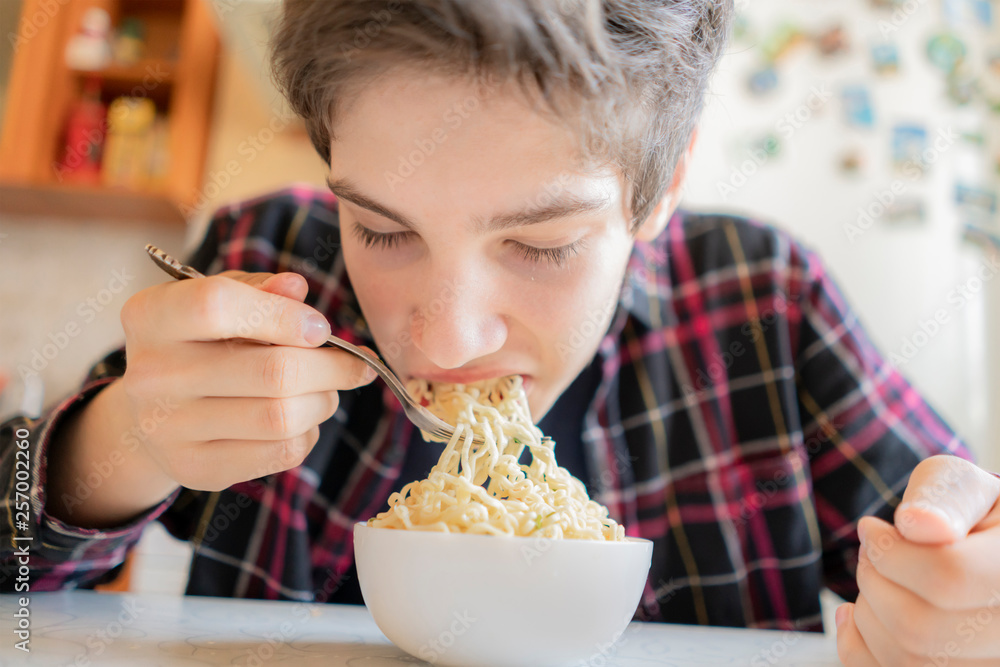 close up photo of young man eating spaghetti from the bowl