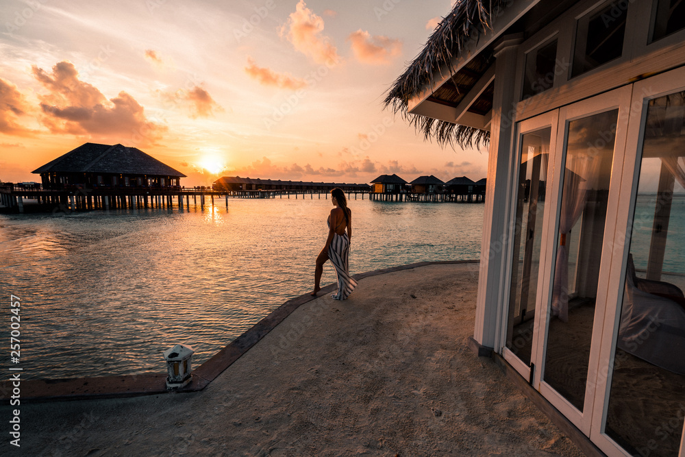 A woman enjoying a sunrise in the Maldives