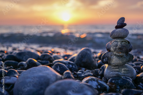 Photography hareubang pebble reflection at sunset over the sea - zen and relaxation