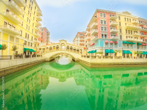 Wide angle view of Venice bridge at Qanat Quartier in the Pearl-Qatar, Persian Gulf, Middle East. Venetian bridge reflecting on canals of picturesque and luxurious district of Doha, Qatar.