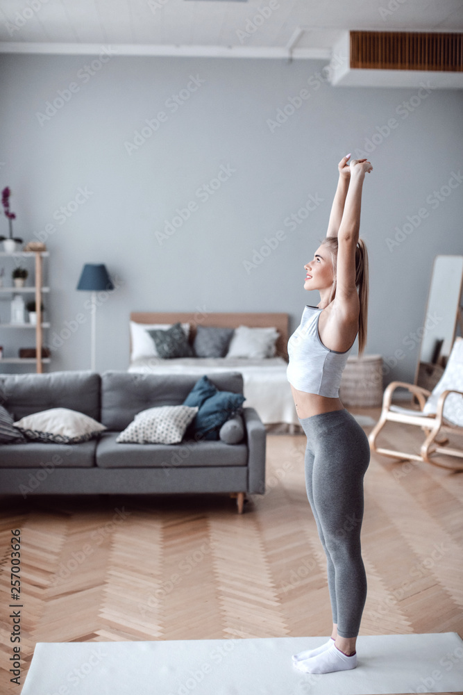 Attractive and healthy young woman doing exercises at home.