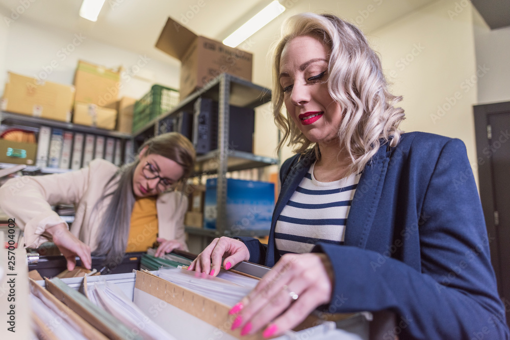 wide angle of attractive office woman working looking files in basement wide angle of attractive office woman working looking files in basement