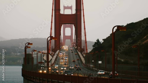 Medium time lapse shot of car traffic lights on iconic Golden Gate bridge in summer sunset San Francisco California.