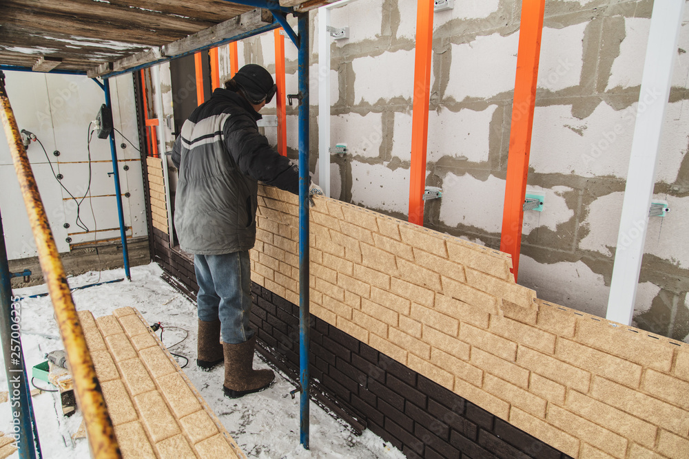 Installing brick siding on the wall of the house Installing brick siding on the wall of the house