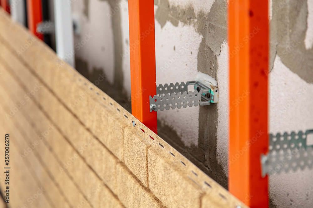 Installing brick siding on the wall of the house Installing brick siding on the wall of the house