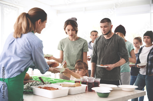 Принти на полотні Volunteers serving food for poor people indoors