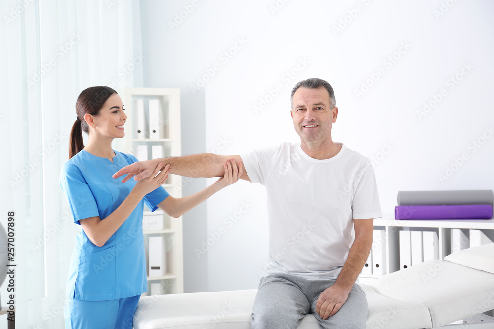 Doctor working with patient in hospital. Rehabilitation physiotherapy