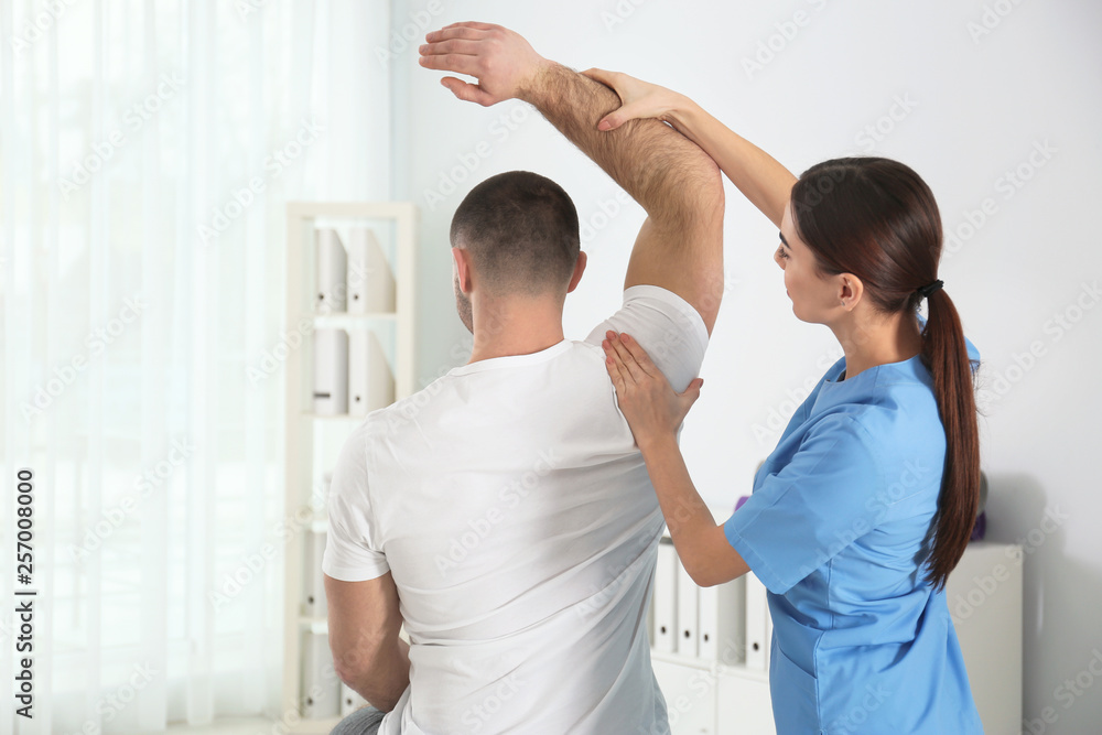 Fototapeta premium Doctor working with patient in hospital. Rehabilitation physiotherapy