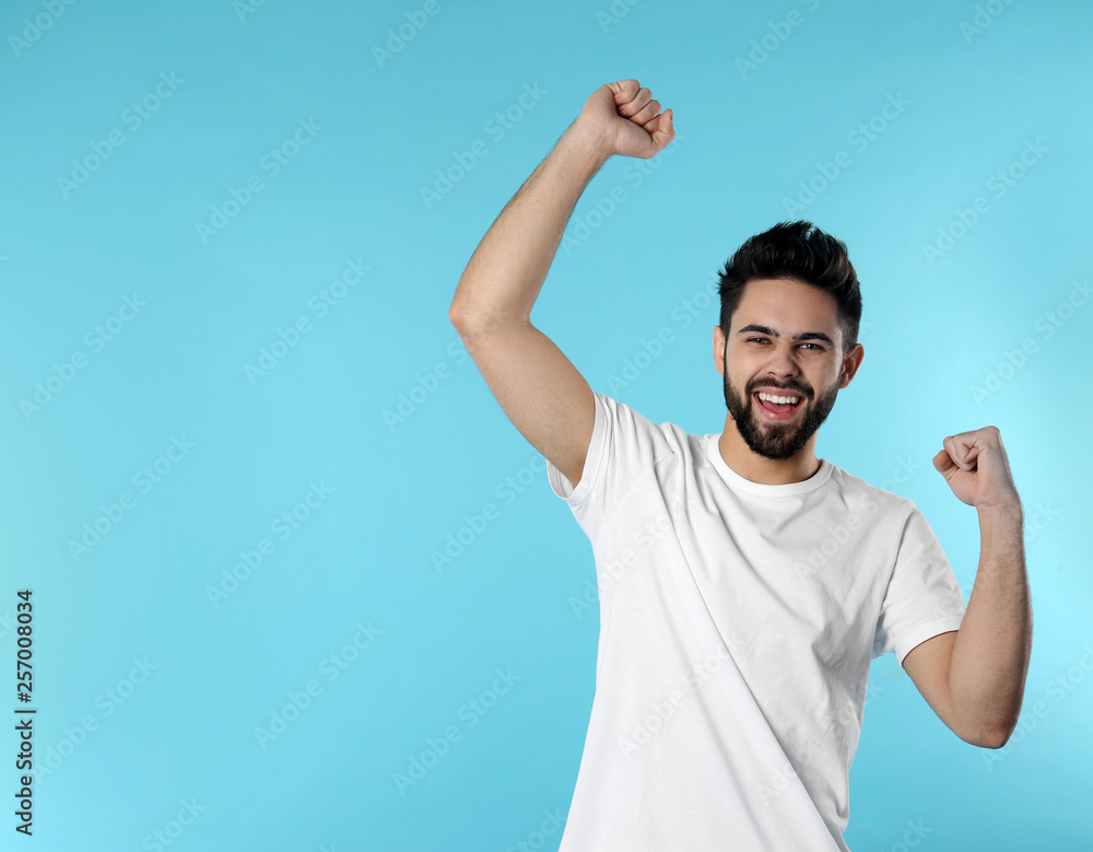 Fototapeta premium Portrait of happy young man on color background. Space for text