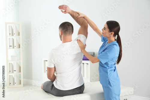 Doctor working with patient in hospital. Rehabilitation physiotherapy photo