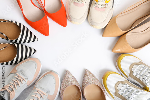 Frame of different shoes on white background, top view with space for text