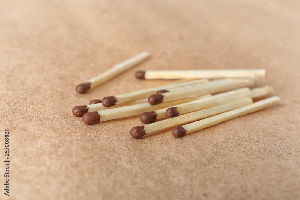 Heap of matches on brown craft paper, closeup Heap of matches on brown craft paper, closeup