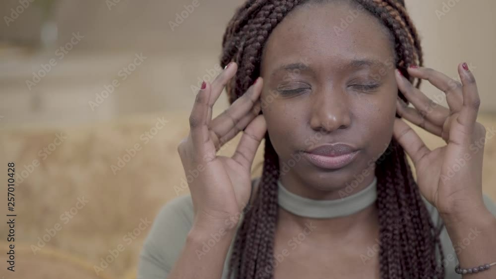 Portrait nervous african american american woman with dreadlocks massaging her head with fingers. Lady has strong headache, migraine. Woman needs the help of a doctor Portrait nervous african american american woman with dreadlocks massaging her head with fingers. Lady has strong headache, migraine. Woman needs the help of a doctor