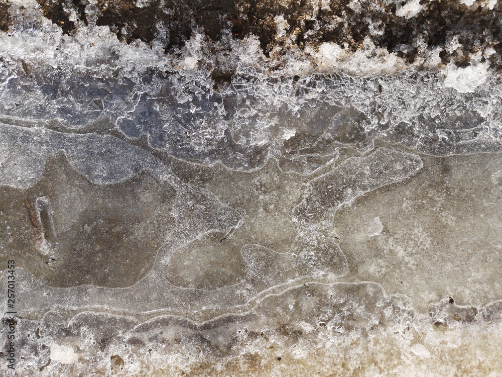 Texture of dirty ice crust on water closeup in Russia, in March