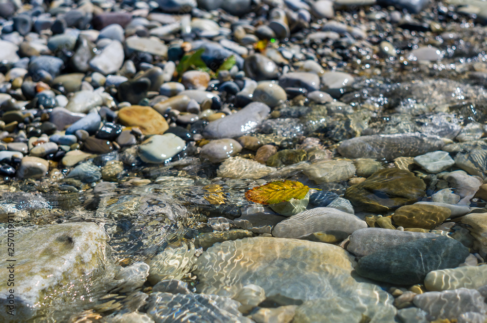 pebble stones on the sea beach, the rolling waves of the sea with foam pebble stones on the sea beach, the rolling waves of the sea with foam