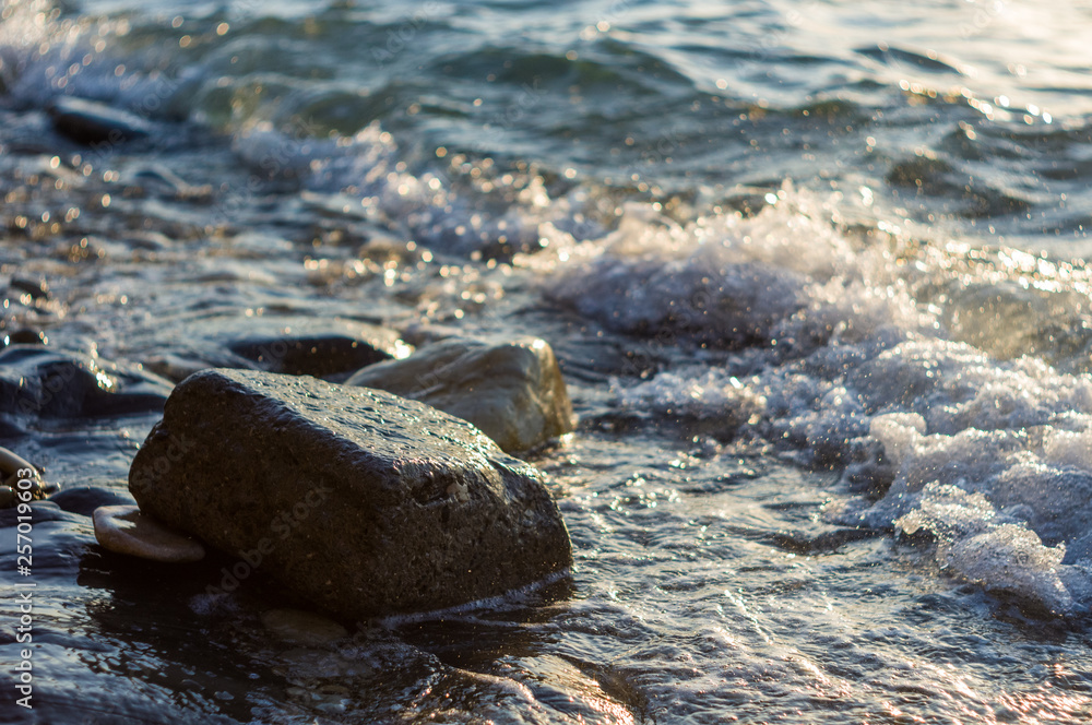 rocky sea shore with pebble beach, waves with foam rocky sea shore with pebble beach, waves with foam